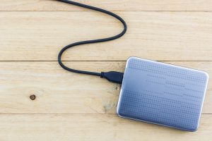 External hard drive for backup on wood background.